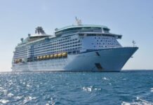 Stock photo of a large cruise ship in the ocean against a clear blue sky.