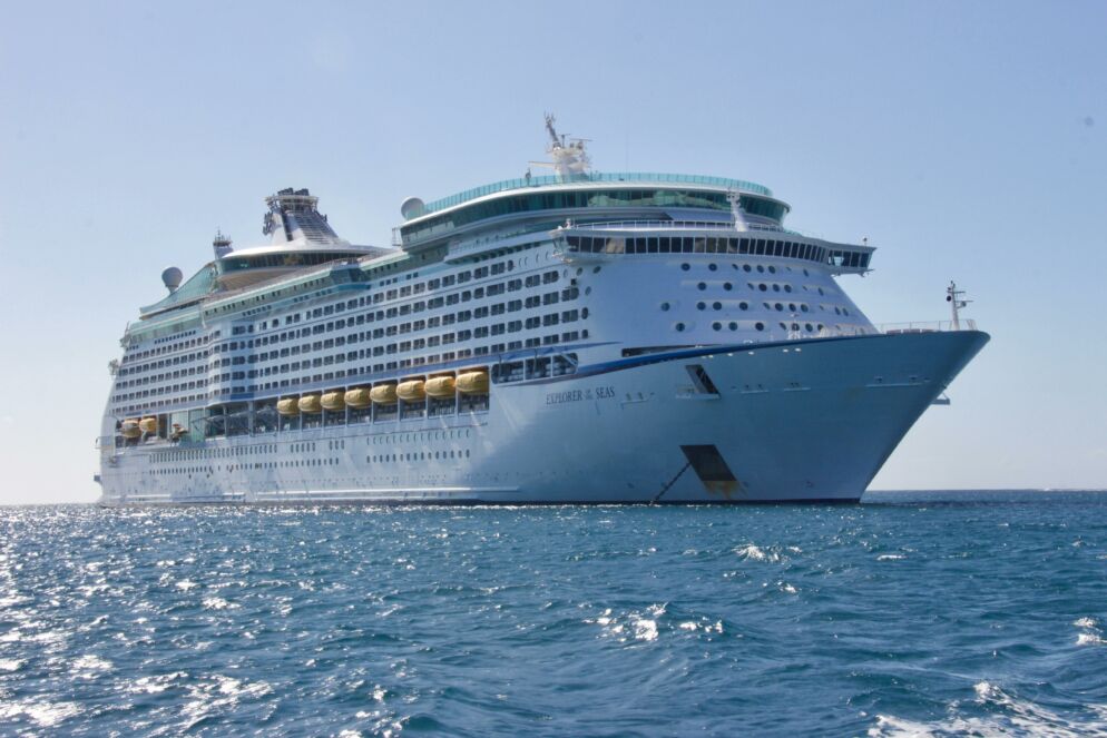 Stock photo of a large cruise ship in the ocean against a clear blue sky.