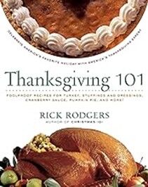 Photo of a white book cover with serif black text that reads "Thanksgiving 101," and below that "Rick Rodgers." On top is a photo of part of a pumpkin pie with white frosting piped around its edges. Below the author's name is a plate of turkey.