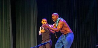 Photo of two dancers performing traditional African step dancing onstage.