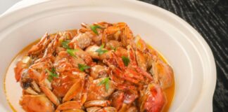 Stock photo of a plastic white plate filled with crab and seafood.