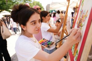 A girl paints outside