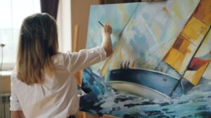 An artist painting a boat on the water