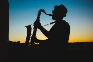 A man plays a saxophone outdoors