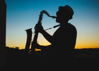 A man plays a saxophone outdoors